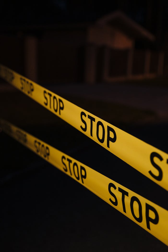 why-choose-us-02 Yellow stop tape in a night crime scene setup, creating a tense atmosphere.